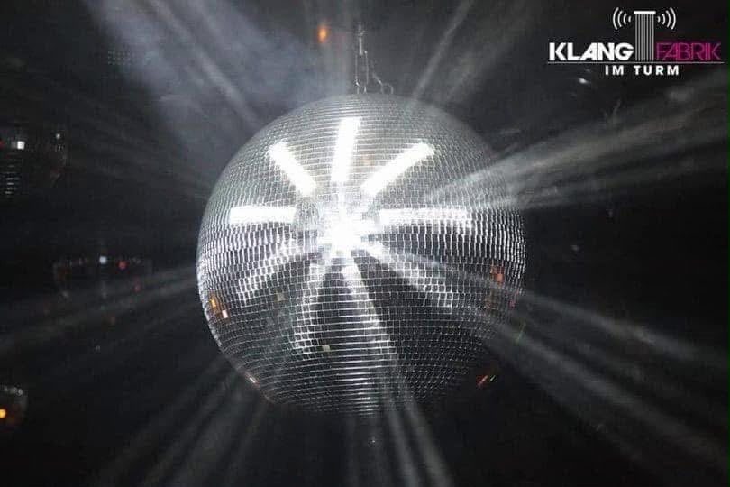 Glitzernde Discokugel mit Lichtstrahlen in der Klangfabrik im Turm